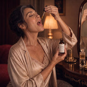 Woman over 45 taking her daily dropper of Moodie Libido Drops at her vanity